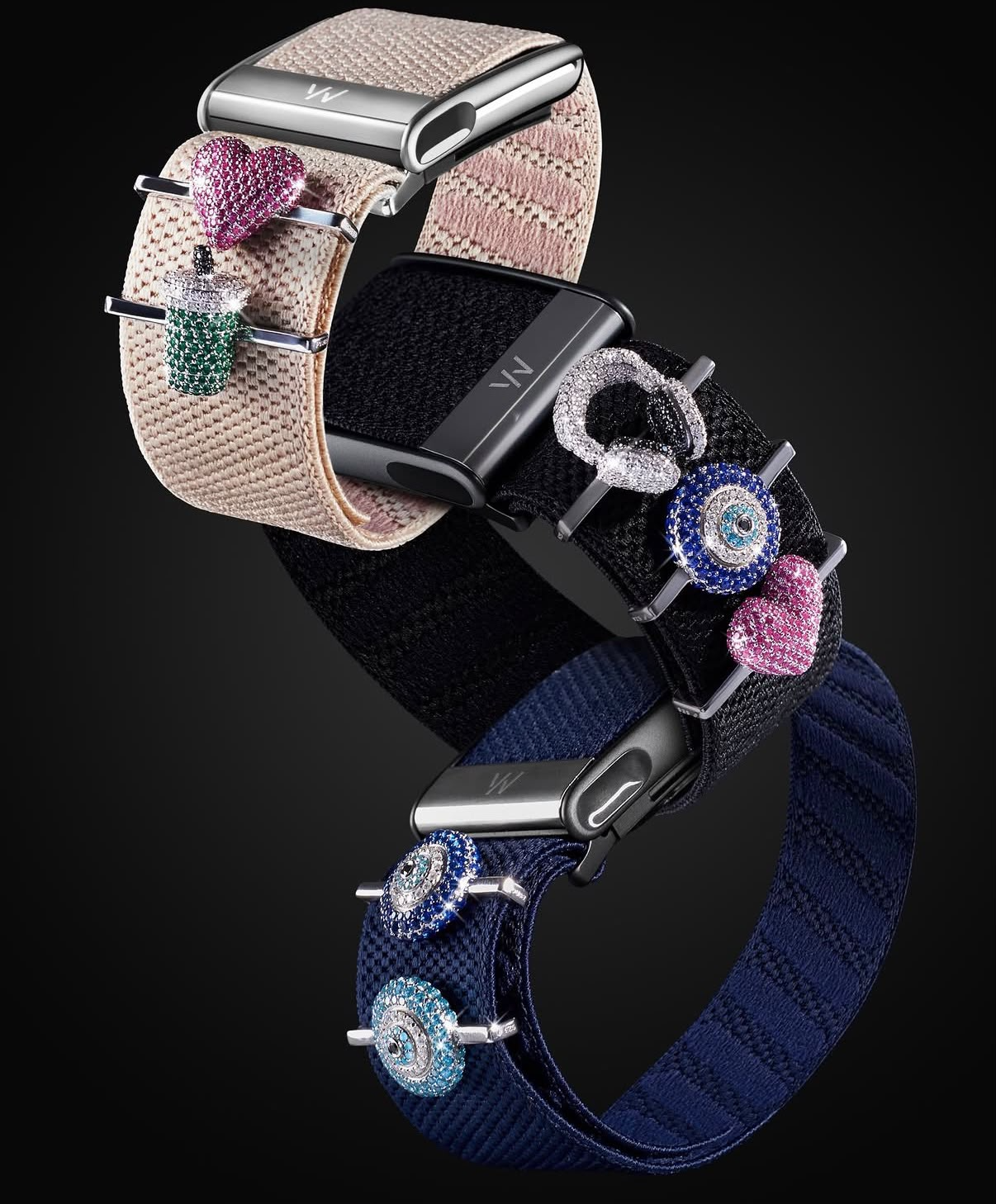 Three WhoopSkin bands in blush, black, and navy styled with colorful stoneset charms